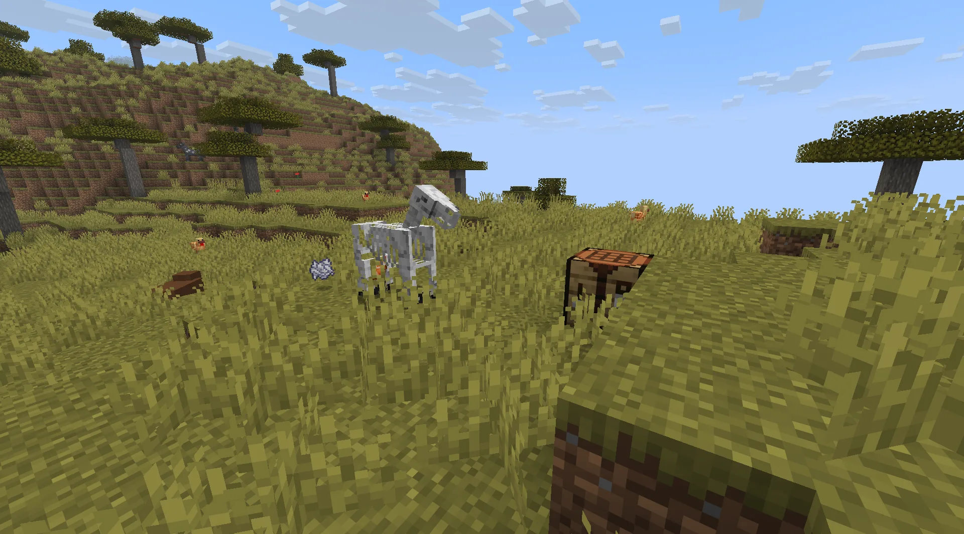 Gameplay scene with a skeleton horse beside a crafting table in a savanna.